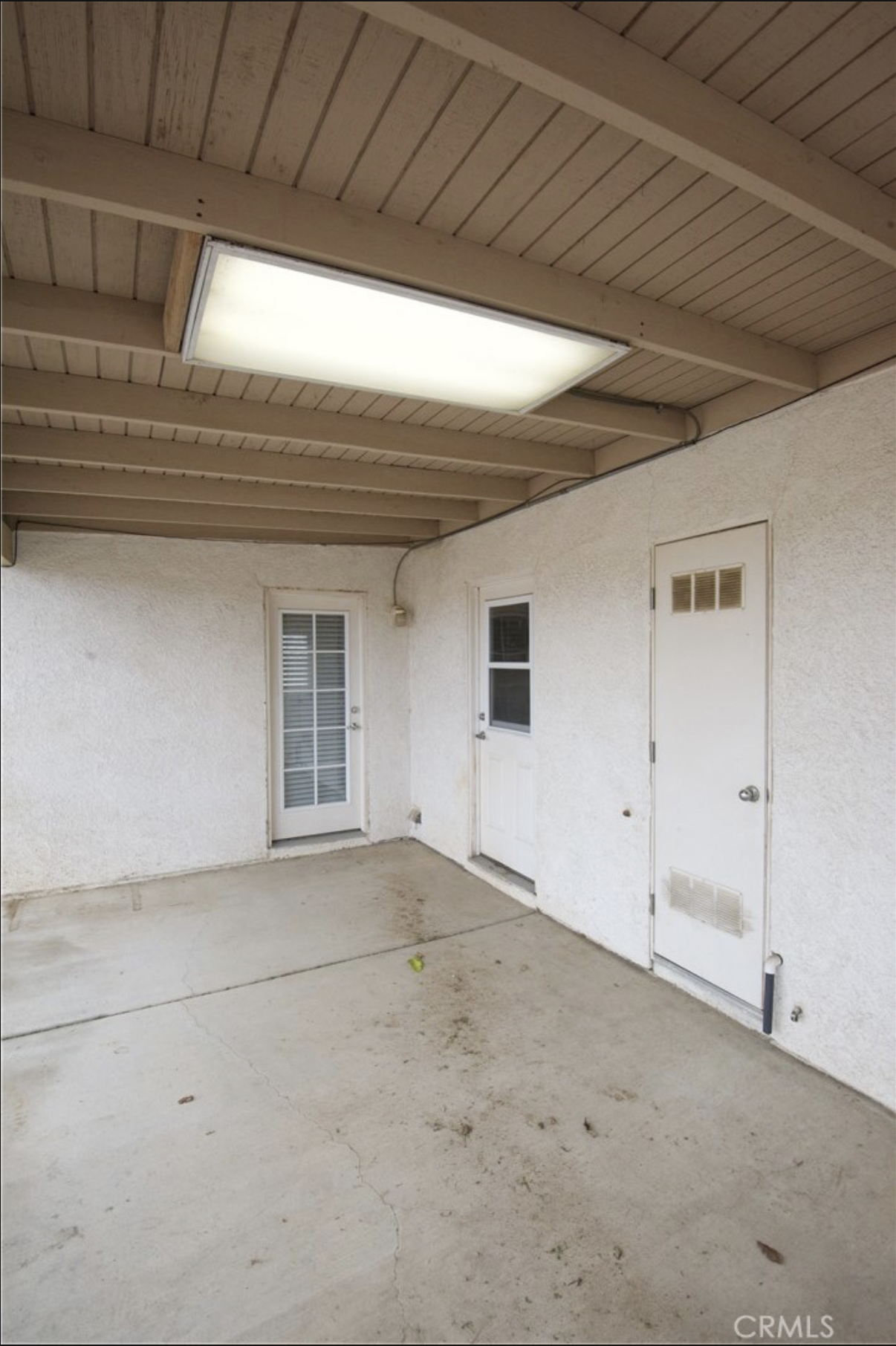 Real listing photo of the covered patio, eye-level, before staging
